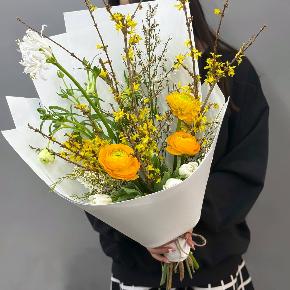 Весенний букет с желтыми ранункулюсами и цветущими ветками форзиции в Щелково