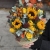 Композиция в сумке "Тональность" из подсолнухов, калл, ягод вибирнума, лимонных роз, скиммии и орхидеи в Щелково